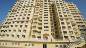 Un hôtel à plusieurs étages doté de balcons, d’une entrée principale et de rampes décoratives.