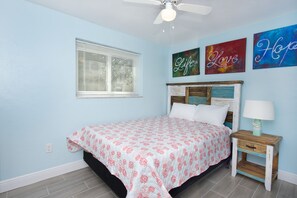 A bedroom with a bed, a nightstand, a ceiling fan, a window with blinds, and three motivational wall art pieces. - π§π»ββοΈShort, Easy Walk to Beach-Mermaid Tales #5 and #6π§π»ββοΈ (Fort Myers Beach)