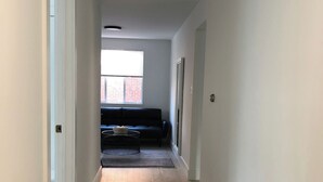 A narrow hallway with a wooden bench, a rug, and a small table. - 4206 Washington Blvd Condos (Arlington)