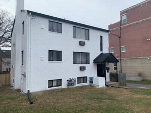 A white two-story building with a black roof, multiple windows, and a small porch area. - 4206 Washington Blvd Condos (Arlington)