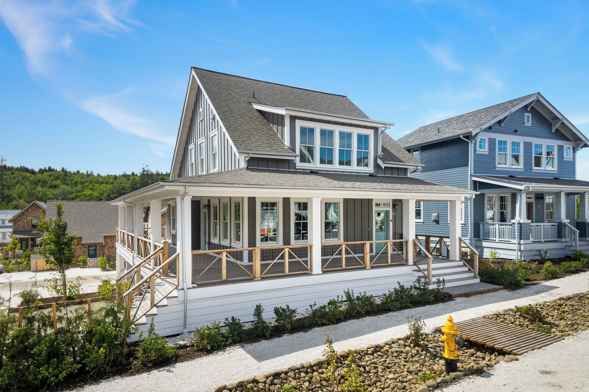 A two-story house with a covered porch and a small deck.