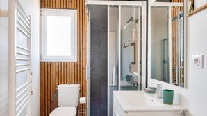 Une salle de bain moderne équipée de toilettes, d’un lavabo et d’une douche.