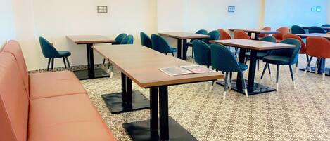 A conference room with tables and chairs, a sofa, and patterned carpet.