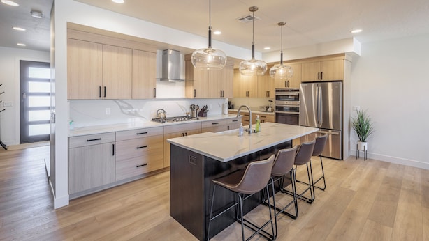A modern kitchen with a central island, stainless steel appliances, and pendant lighting. - Stylish Poolside 3BR w/ Game Room & Pool Table (St. George)