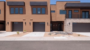 A modern multi-story residential building with a flat roof, large windows, and a stone facade. - Stylish Poolside 3BR w/ Game Room & Pool Table (St. George)