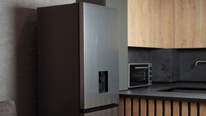 A modern kitchen with a built-in refrigerator, a microwave, and wooden cabinets.