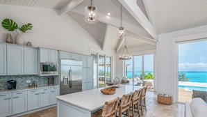 Una cocina espaciosa con una isla grande, electrodomésticos modernos y vistas al océano.