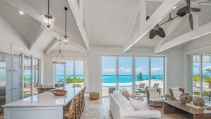 Una cocina amplia con una isla grande, un comedor y una sala de estar con vista al océano.