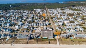 An aerial view of a coastal residential area with a beach access sign, indicating proximity to the beach. - Blue Snapper 3 Bedroom Condo by RedAwning (Carolina Beach)