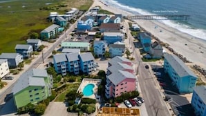 A coastal hotel with multiple buildings, a beach, and a pier. - Beach Bliss 1 Bedroom Condo by RedAwning (Carolina Beach)