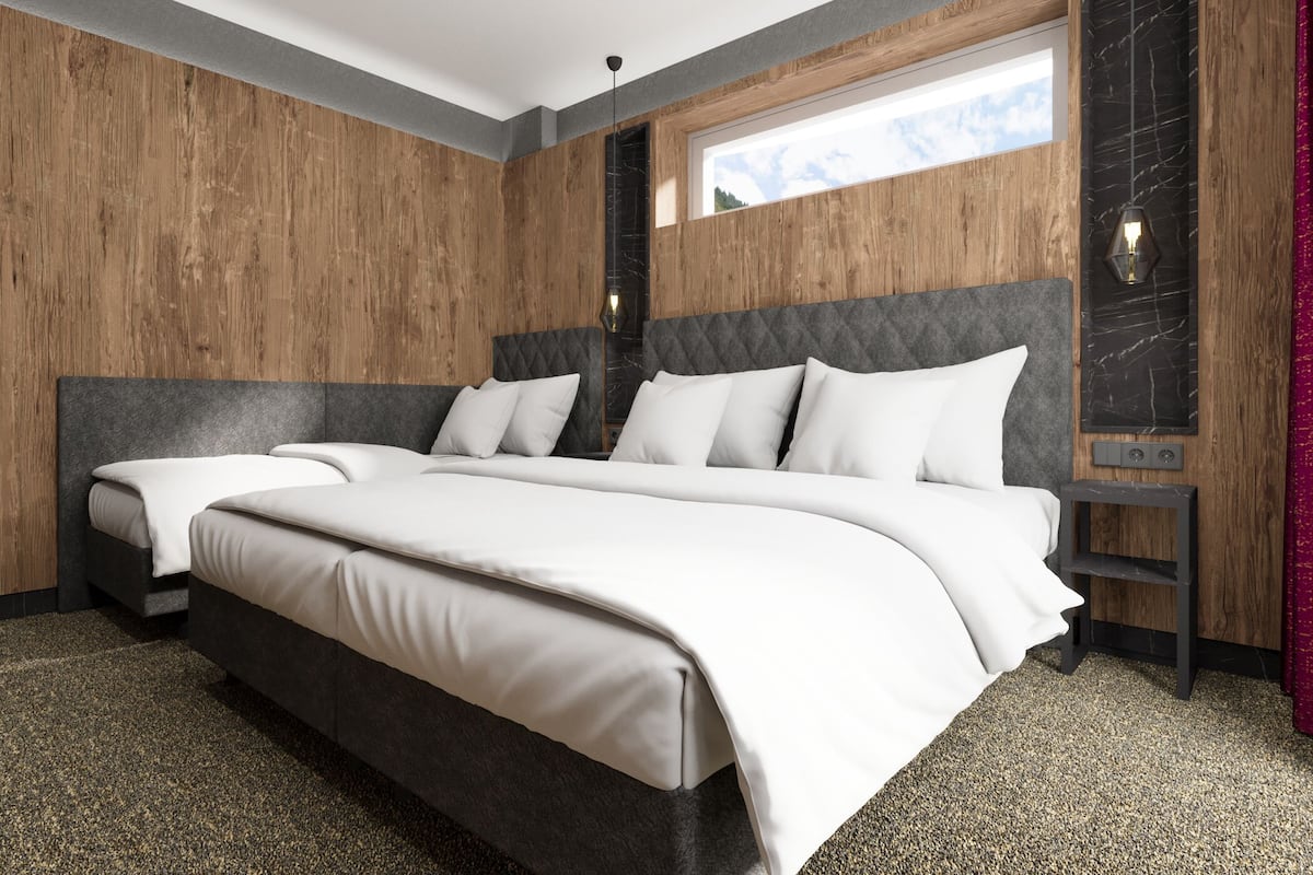 A modern bedroom with a large bed, two bedside tables, and a window with a view.