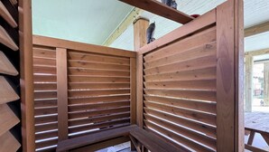 Un banc en bois avec des lattes horizontales, un poteau en bois et un sol en béton.