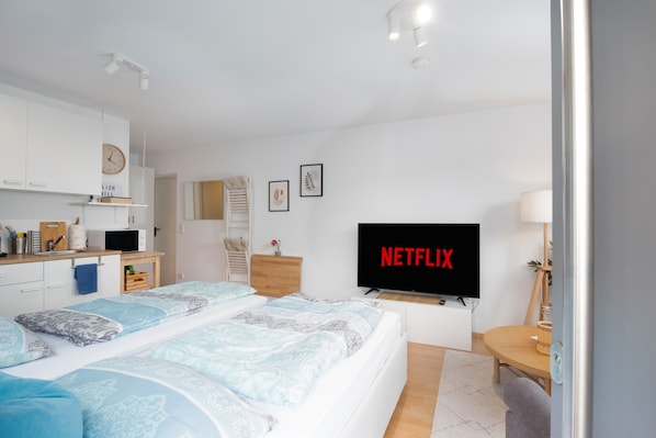 Une chambre moderne équipée d’un lit, d’une télévision, d’un bureau et d’une armoire.