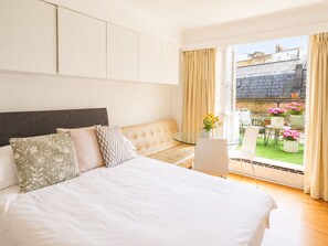 Une chambre avec un lit, un canapé, un ordinateur portable et une vue sur l’extérieur.