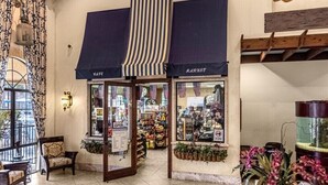 En butik med två markiser, var och en märkt med texten ”MARTET”, och ett varierat utbud av varor utställda i skyltfönstret.