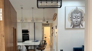 A modern kitchen with a central island, pendant lighting, and a dining area with bar stools. - Cottage-sleeps 5-parking-near Beach-fireplace (Buncrana)