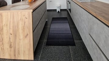 Een oven, een kookplaat, een vaatwasser, kookgerei, borden en bestek