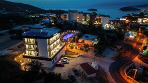 Un hotel moderno con varios pisos, una piscina y vista al mar.