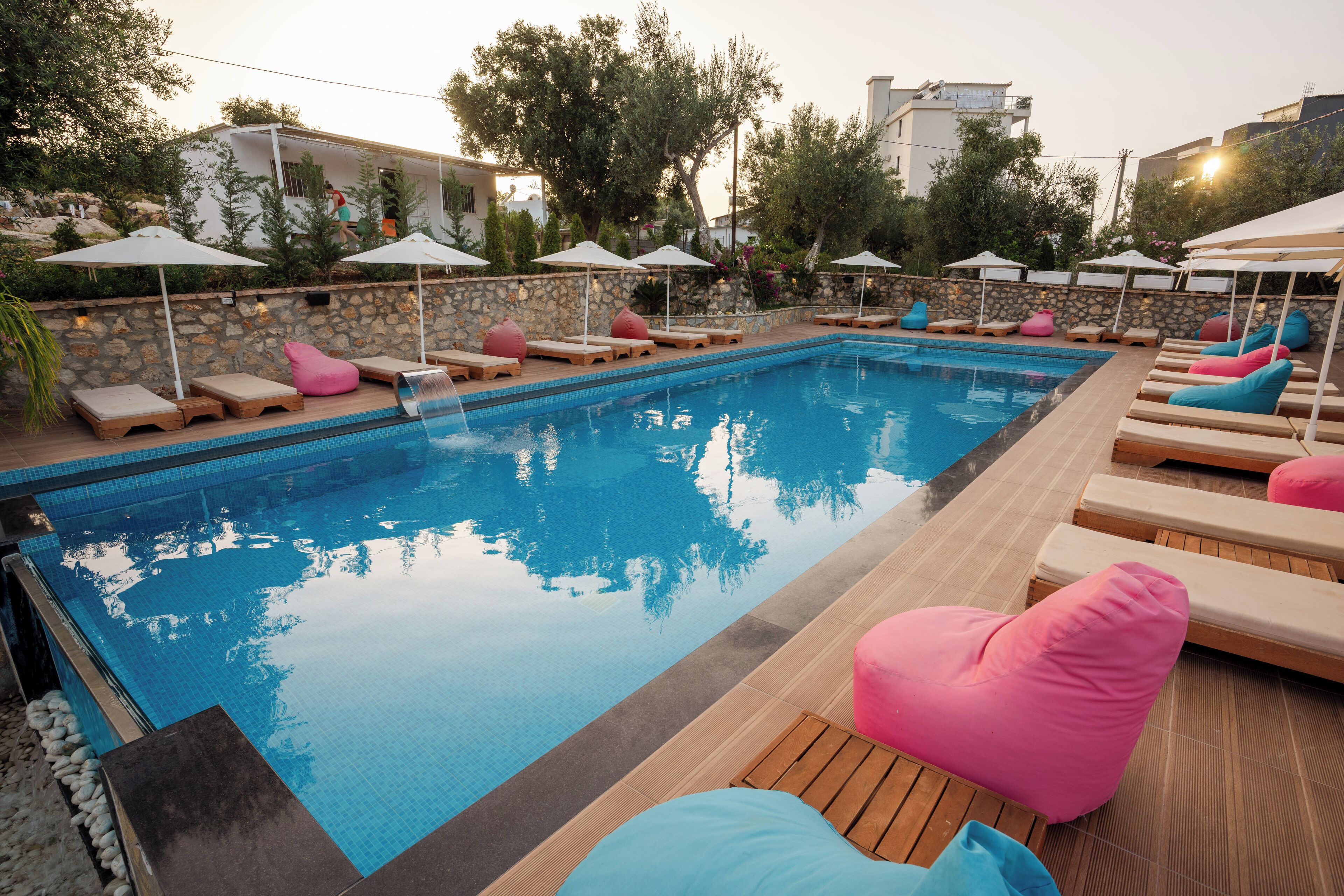 A swimming pool with lounge chairs and umbrellas.