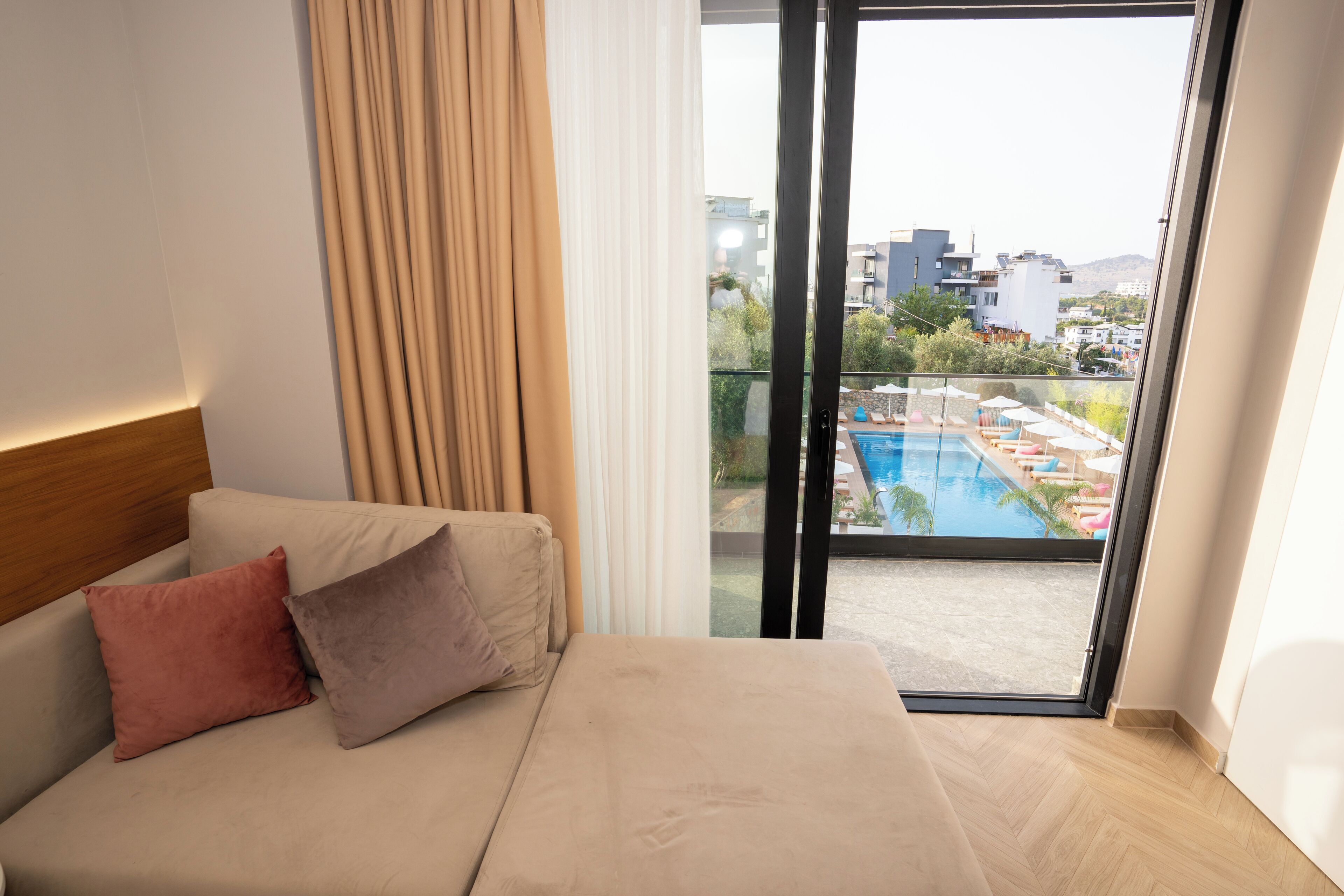 Et hotelværelse med seng, udsigt til en swimmingpool og en balkon.
