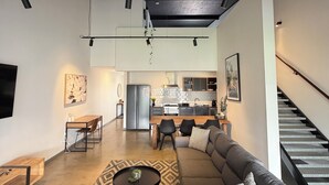 A modern living room with a grey sofa, a wooden coffee table, and a patterned rug. -  Modern New Yorker Inspired Townhouse~ Full kitchen-Fast Wifi- Near Bunbury (Australind)