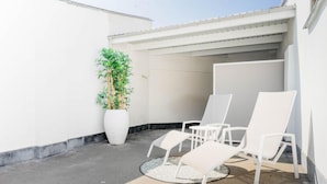 A small outdoor seating area with white chairs and a large potted plant. - Charming Ostend Home Near Beach City Center (Ostend)