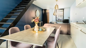 A modern kitchen with a dining area, a staircase, and a view of the city. - Charming Ostend Home Near Beach City Center (Ostend)