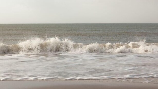 Une plage où les vagues déferlent sur le rivage.