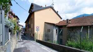 A narrow street with buildings on either side, a no parking sign, and a clear sky. - Greenway Apartment by Wonderful Italy (Colonno)