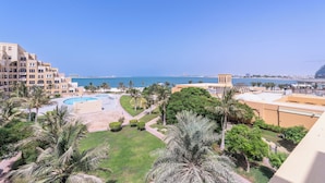 Un resort con piscina, palmeras y vista al mar.