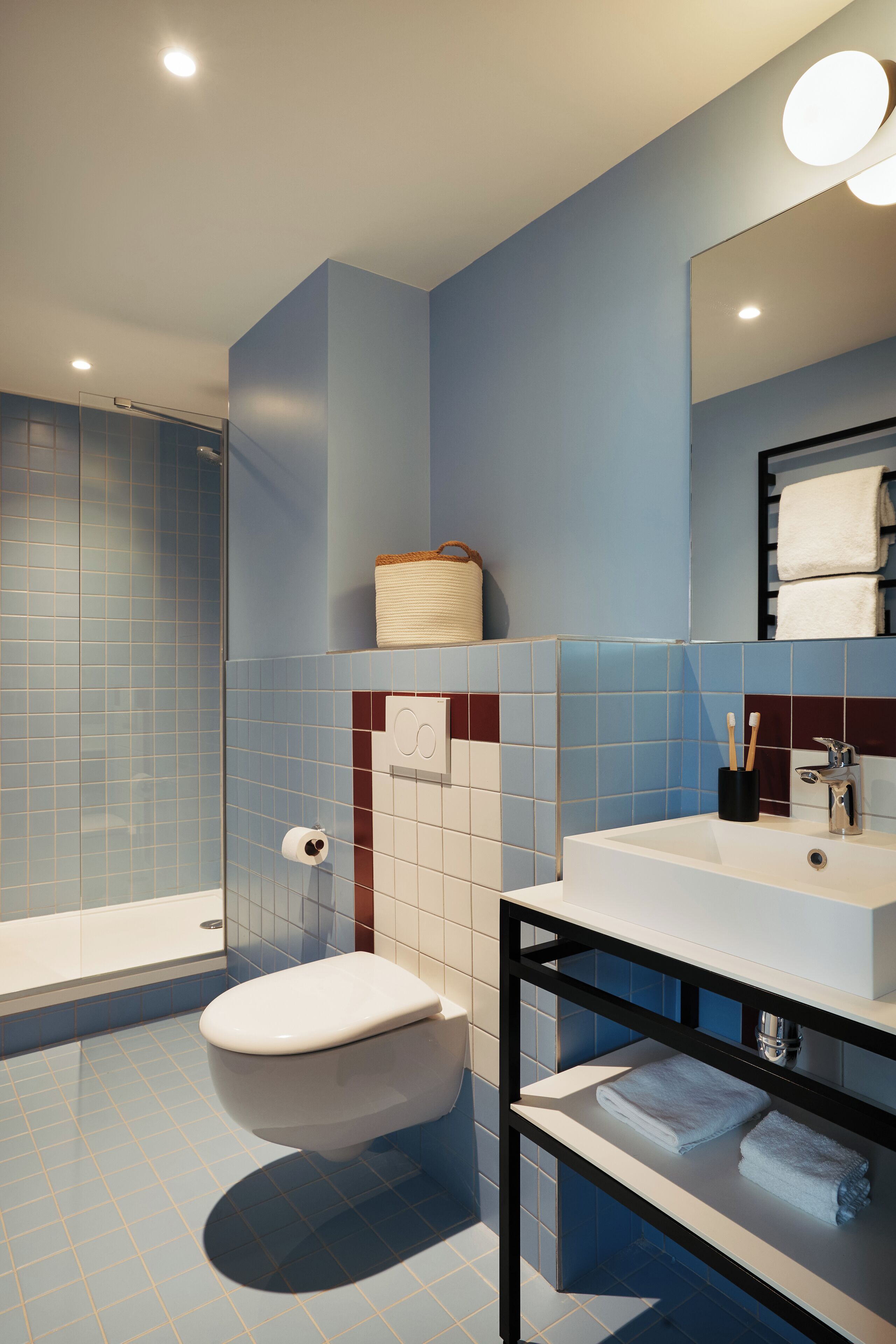 Une salle de bain moderne équipée de toilettes, d’un lavabo et d’une douche.