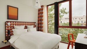 Een hotelkamer met een groot bed, een bureau en een stoel.