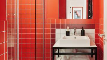 Familie appartement | Badkamer | Een douche, een haardroger, handdoeken, zeep