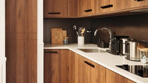 Een moderne keuken met houten kastjes, een wit aanrecht en roestvrijstalen apparatuur.