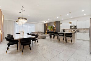 Una cocina moderna con armarios blancos, una isla central y electrodomésticos de acero inoxidable.