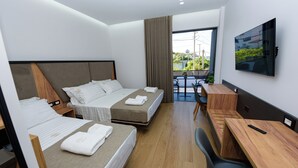 Een moderne hotelkamer met twee bedden, een bureau en een televisie.