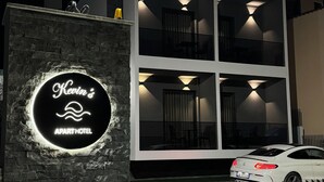 Een modern gebouw met een bord waarop staat 'Kevin's Apart Hotel'.