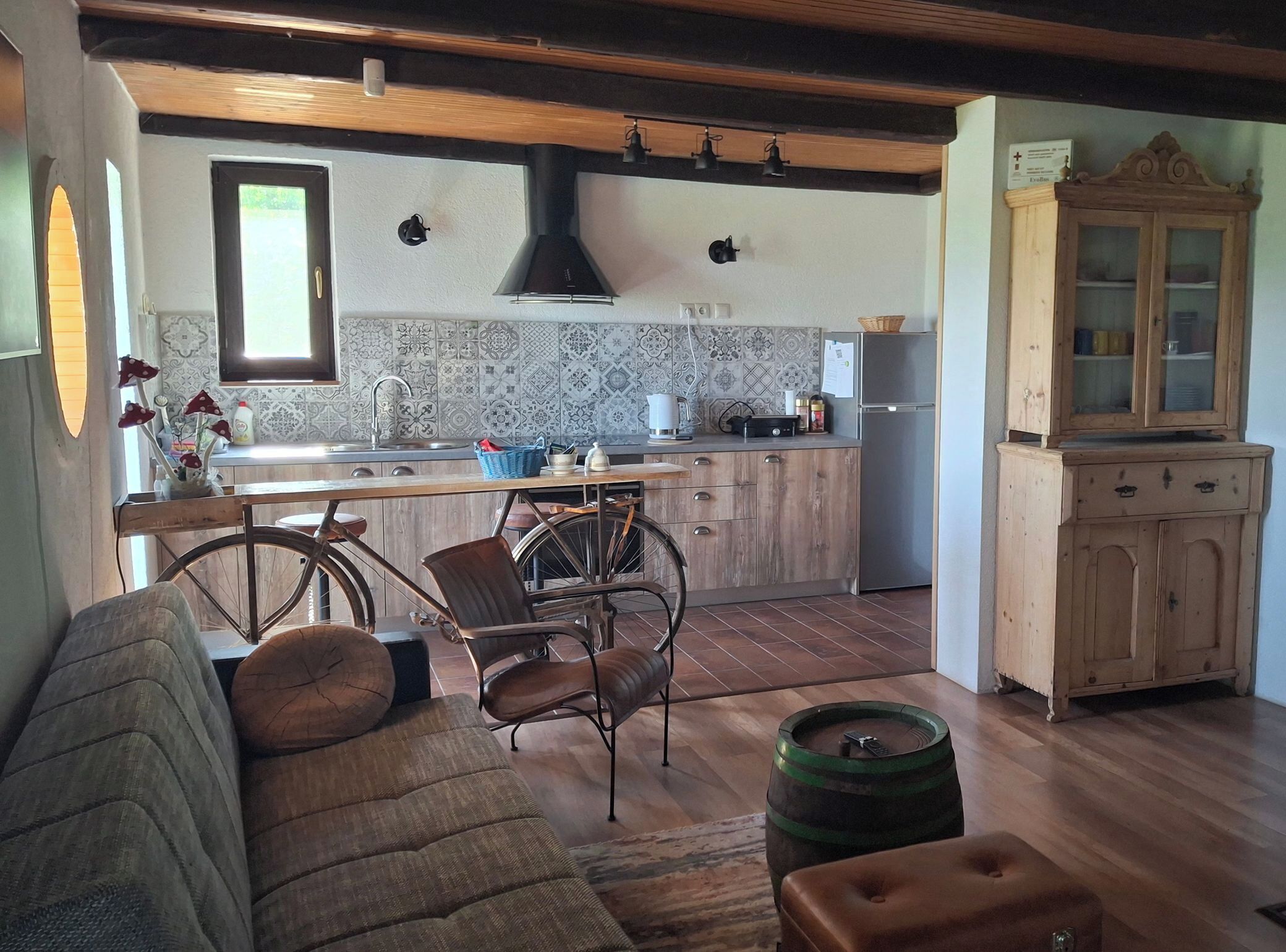 Une cuisine avec une table à manger en bois, des chaises, un vélo et un meuble.