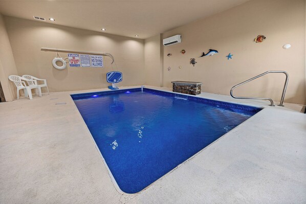 A swimming pool with a lifeguard chair, a shallow water warning sign, and a starfish decoration on the wall. - Panoramic Paradise Splash – A Splash of Fun All Around (SEVIERVILLE)