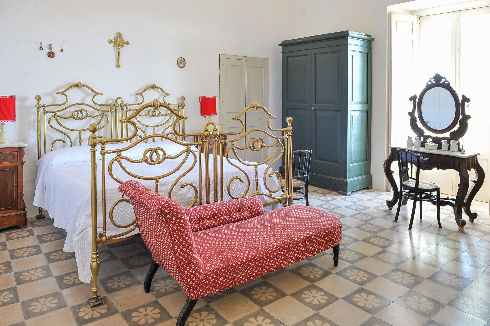 A room with a bed, a chair, a dresser, and a mirror.