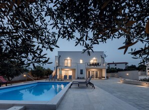 A modern two-story house with a swimming pool, outdoor seating, and a balcony. - Holiday Home Milutin 1 (Vrsi)