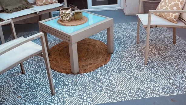 Un patio con una mesa, sillas, un banco y una planta en maceta.
