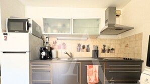 Uma cozinha compacta com micro-ondas, fogão, pia e armários.