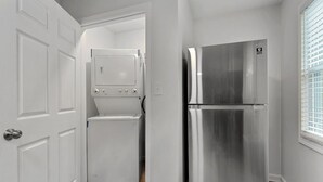 A compact kitchen with a stainless steel refrigerator and a built-in washer and dryer. - 2 bedroom Rustic Duplex-Free Parking (Lithia Springs)