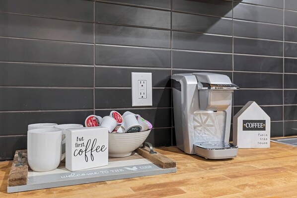 Una estación de café con cafetera, tazas y un cartel que dice 'Welcome to the Coffee House'.