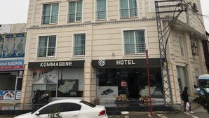 A multi-story building with a sign reading "KOMMAGENE HOTEL" at the ground level. - Kommageneiz Hotel (Kahta)