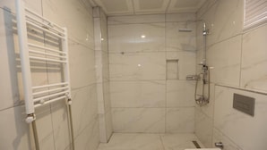 A modern bathroom with a walk-in shower, a toilet, and a towel rack. - Kommageneiz Hotel (Kahta)