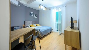 A compact bedroom with a bed, bedside table, desk, chair, and a TV on a stand. - Vera Studio Deluxe With Oldtown View (Zadar)