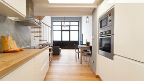 A modern kitchen with white cabinets, a wooden countertop, and stainless steel appliances. - Milan Lambrate M2 Center (Milano)