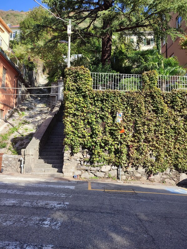 A staircase leading up to a stone wall with a metal fence. - Paradise View (Como)